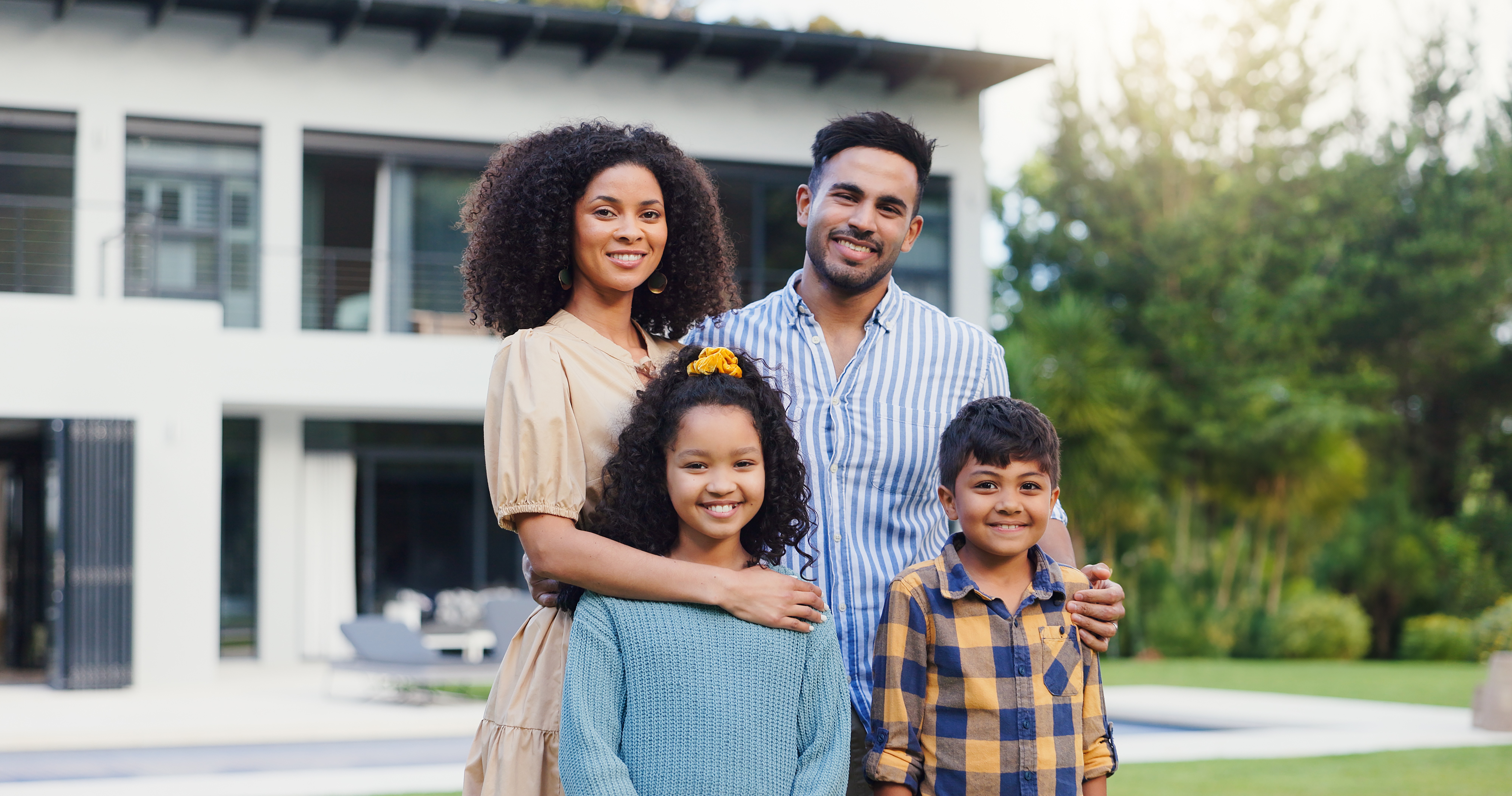Family standing together in front of a modern South Florida home