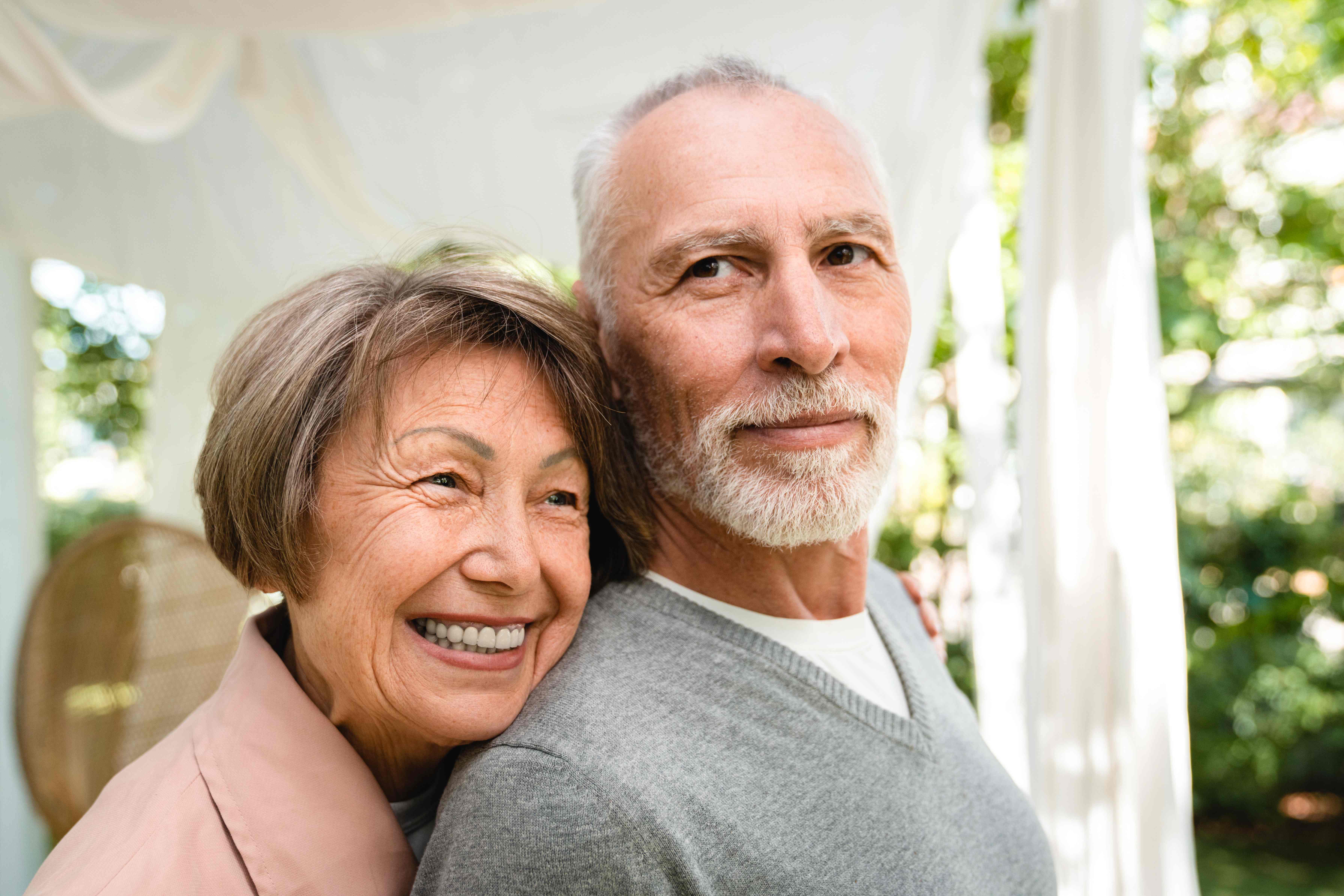 Affectionate senior couple smiling and embracing outdoors